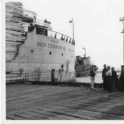 Barge Hilda loaded with lumber with tug in front