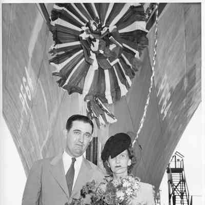 Mrs. Gus Johnson holding roses at christening of PF-64 USS Knoxville