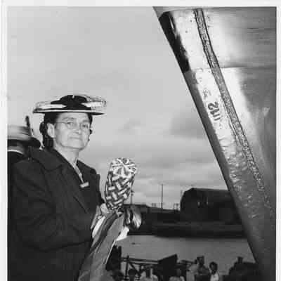 Mrs. Samuel North standing at bow of ship with Champagne Bottle 1944