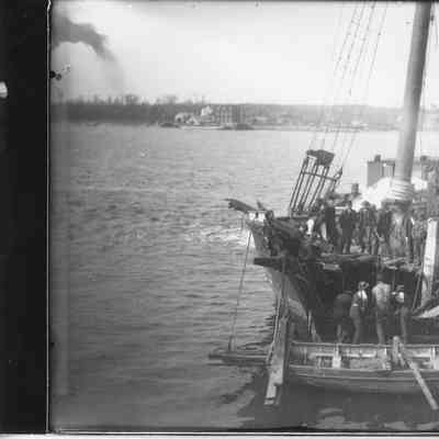 Men board and on board three masted vessel