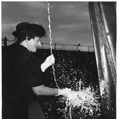 Mrs. John Butterweck hitting Champagne bottle against the PF-66 USS Reading