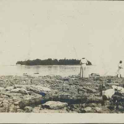woman and girls on rocky shore