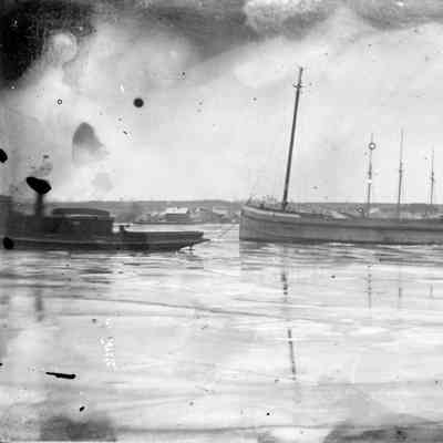 Tug towing ship through canal