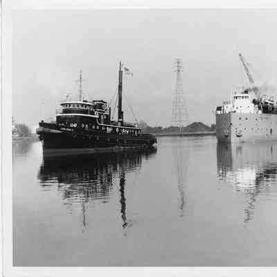John Roen IV pulling steamship with load of logs