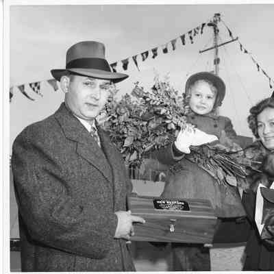 Sponsors of US Navy Frigate PF-71 New Bedford holding sponsor case and flowers