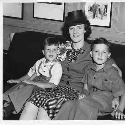 Mrs. C. W. McKee sitting on couch between her two sons