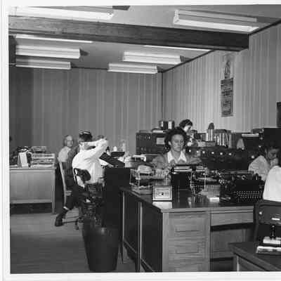 Unidentified men and women at desks at L.D. Smith office