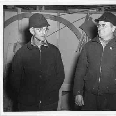 Tow workers in stormy Kromer hats in workshop