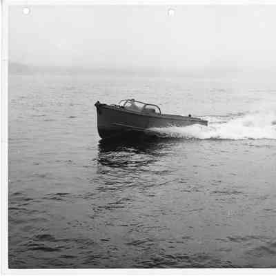 Metal Boat underway with man steering