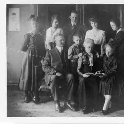 Elderly man and women seated with eight children