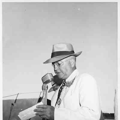 Leathem D. Smith at microphone holding document