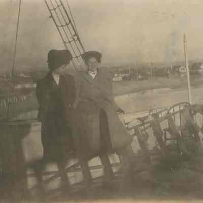 Women leaning against rail of vessel
