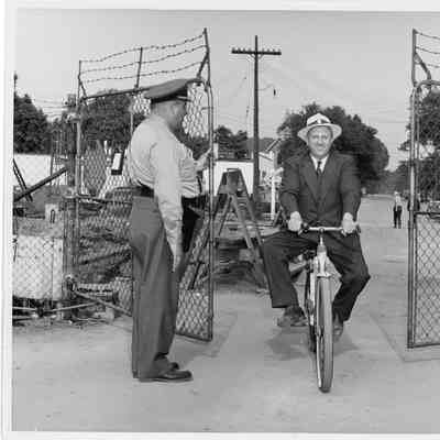 C. Ray Christianson riding bike through gate at Shipyard
