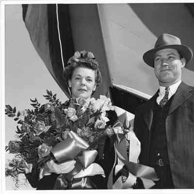P-568 sponsor Mrs. W. DeFaut holding flowers next to man with P-568 behind them