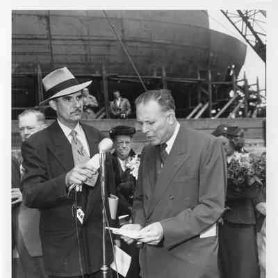 Man talking at microphone Badger launching September 6, 1952