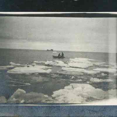 Two men in rowboat bringing in mail on Europe Bay