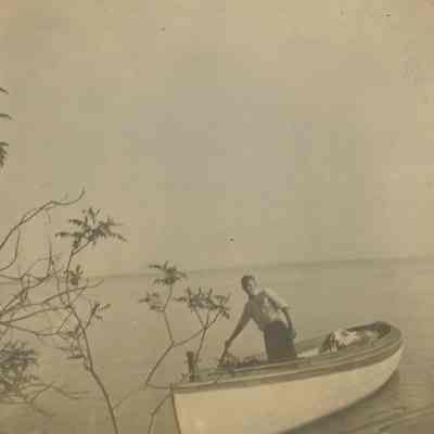 Young man standing in skiff