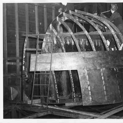 Two welders working on a bow frame