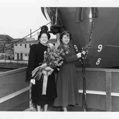 Ship sponsor and woman holding bouqet of roses at christening of Chicago Fire Boat at Christy Corp 1949