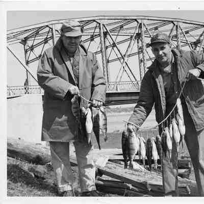 Les Meyers and Art MacMillan holding string of fish between them
