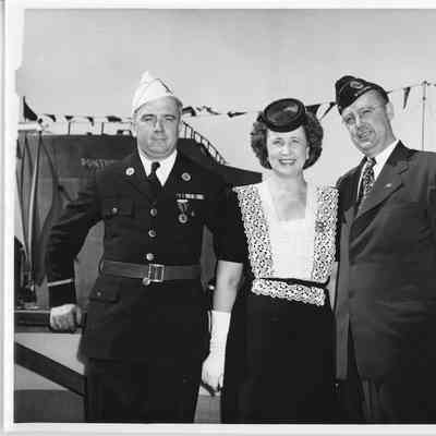 Mrs. Lawrence H. Smith standing between two men
