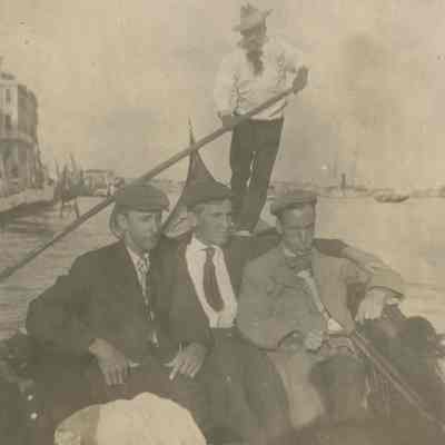 Three men sitting in Gondola in Venice Italy