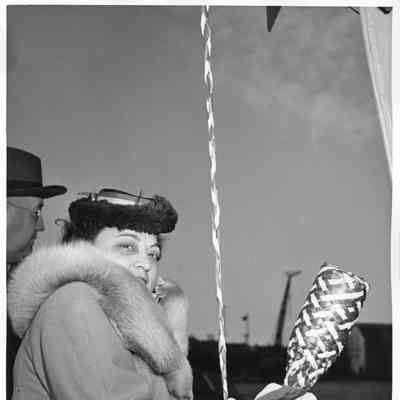 Mrs. Alan Ashcroft with christening bottle posed to subchaser PC-1263