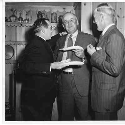 L.D. Smith holding paper plates with two men