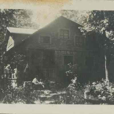 people seated on steps of Weitlich cottage 1916