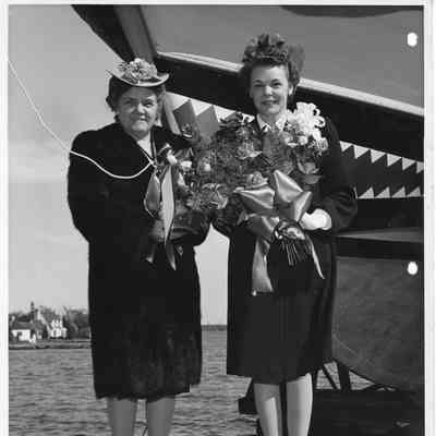P-568 sponsor Mrs. W. DeFaut holding flowers next to another woman holding christening bottle April 12, 1944