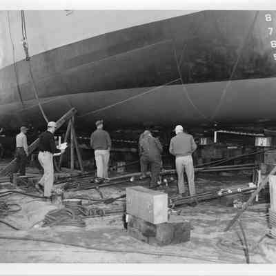 Men standing under LST-1170, May 22, 1954