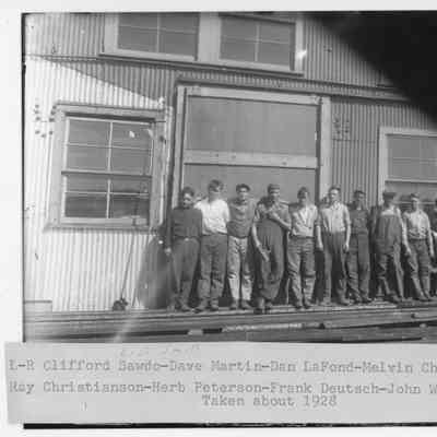 Ten L.D. Smith works in front of building 1928