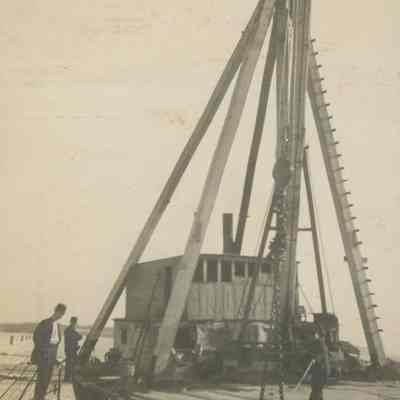 Workers operating crane on barge