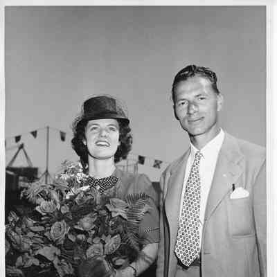 Mrs. C. W. McKee holding roses alongside man at PC-1174 christening