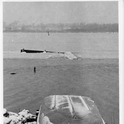 Rowboat on shore with dock sinking in background 1959