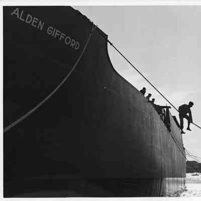 Men holding mooring ropes attached to Alden Gifford