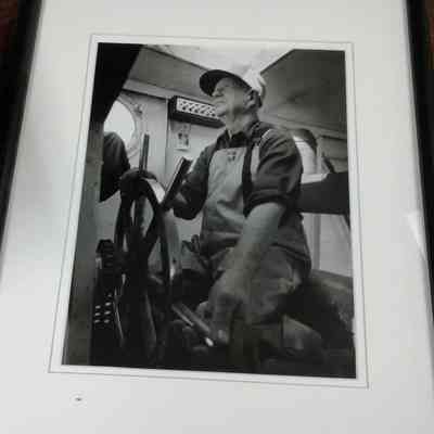 Framed photograph of How Weborg at the helm of the Freitag