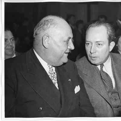 Two seated men talking at ship launching