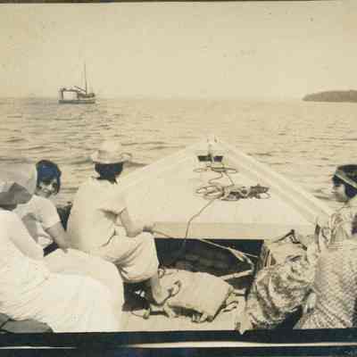 Group of people riding pound boat with Marion in distance 1925