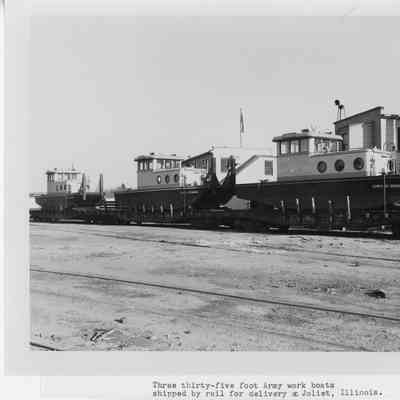 Three 35' army work boats on railcars in Joliet, Illinois