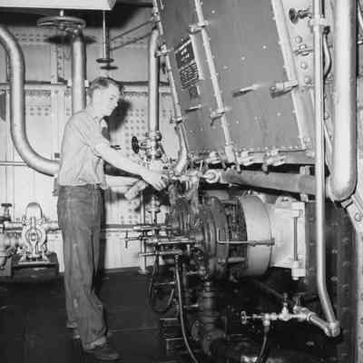 Young crewman adjusting valve on lighthouse tender Hollyhock