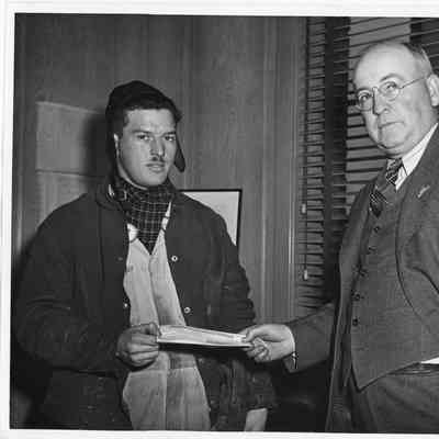 Leathem D. Smith Handing something to unidentified male employee