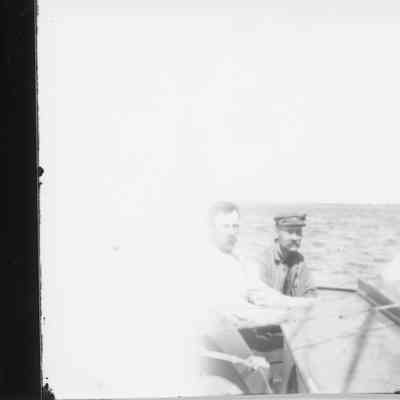 Three unidentified men on deck of boat underway