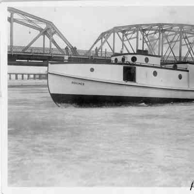 Fishing tug Roamer underway in bay of Sturgeon Bay with Michigan Street Bridge in background