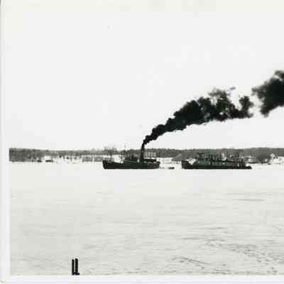 Tugboat towing push tug in icy water