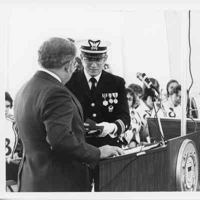Omer Mickelson presenting pendant to USCG rear admiral 1979