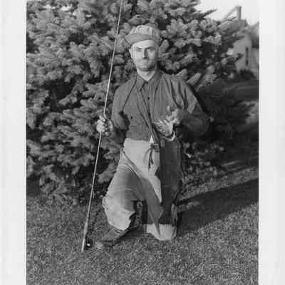 Archie Deni kneeling on grass holding German brown trout 1947