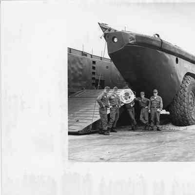 Five men posing next to US Army Barc 24 with life ring