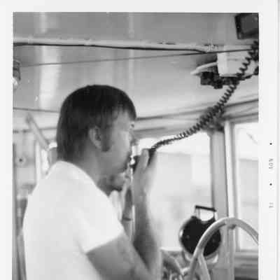 Captain of the tug John Purves behind wheel in pilothouse 1974