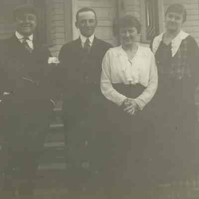 Four people in front of house